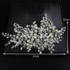 A delicate bridal headpiece featuring intricate white pearls and clear rhinestones displayed on a black square box.
