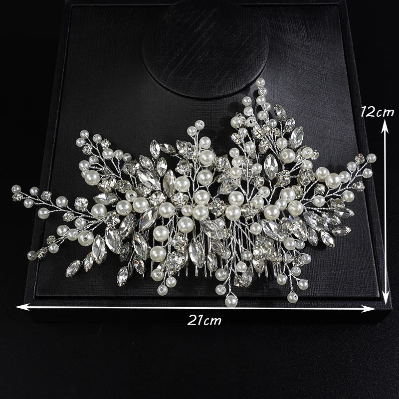 A delicate bridal headpiece featuring intricate white pearls and clear rhinestones displayed on a black square box.