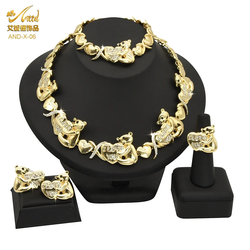 A gold heart crystal jewelry set featuring a necklace and earrings displayed on a black stand.