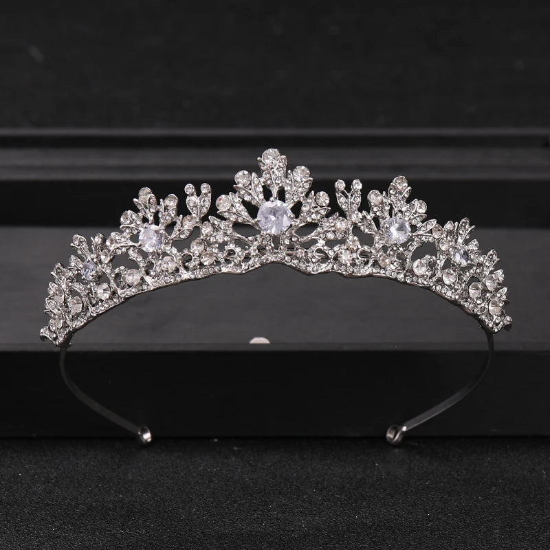 A sparkling crystal rhinestone bridal tiara headpiece displayed on a dark surface.