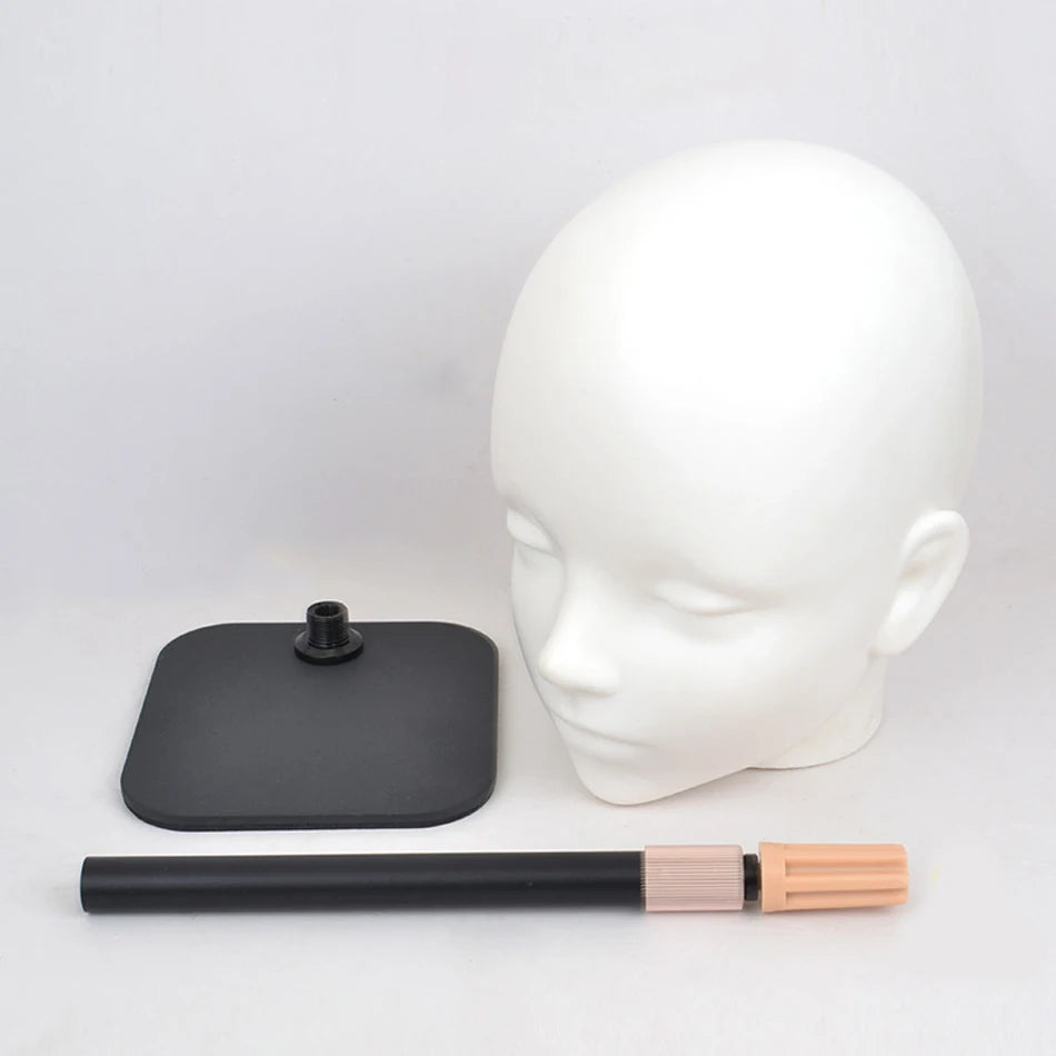 A white professional mannequin head with a black stand and a wooden brush attached.