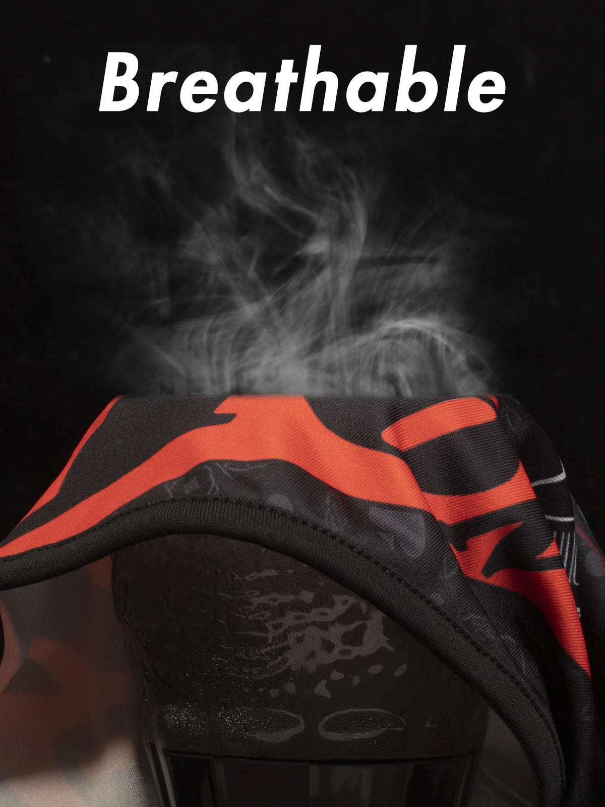 A close-up of a black balaclava helmet liner with orange accents, demonstrating its breathable material.