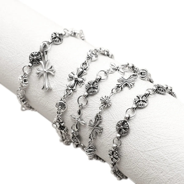 Une pile de bracelets en chaîne argentés gothiques vintage portés au poignet.