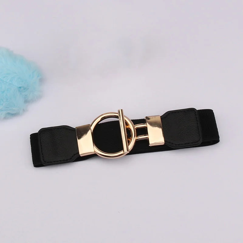 A black adjustable fashion belt with a gold round buckle and a light blue fluffy pom-pom.