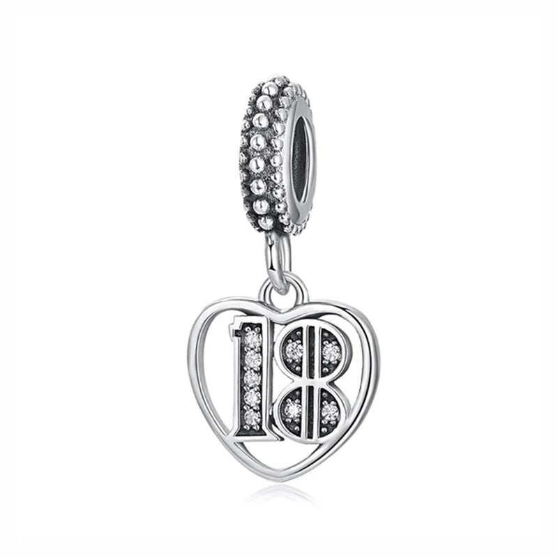A silver family tree charm necklace featuring the number 18 in a heart shape, adorned with small stones.