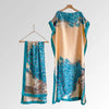 A flowing peach and teal floral butterfly peacock cape shawl displayed on a hanger.