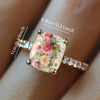 Bague statement dorée avec une pierre carrée illustrant une rose rétro et de petits accents clairs.