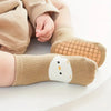 A pair of beige cartoon animal socks for a child's foot