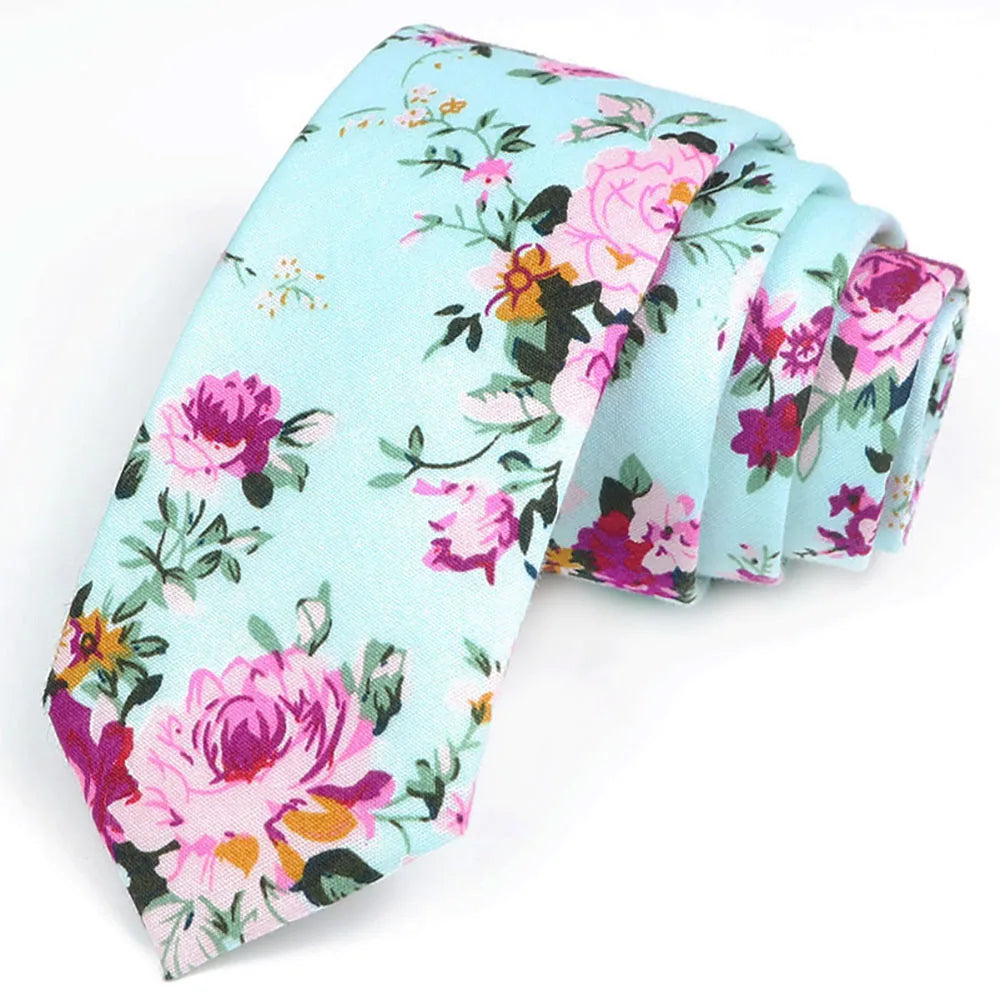 Une pile de nœuds de coton à motifs floraux élégants bleu clair avec des roses roses et violettes et de la verdure.