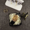 A luxury gold-toned watch is placed on a bed of white shredded material next to a black leather belt and a gold-toned buckle.