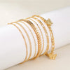 Goldiges Vintage-Schmetterlingsherz-Armbandset auf einer weißen Handgelenk