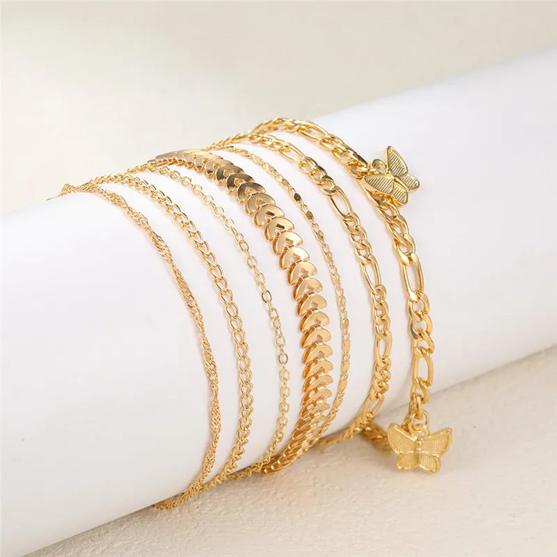 Goldiges Vintage-Schmetterlingsherz-Armbandset auf einer weißen Handgelenk