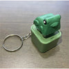 A green frog-shaped fidget keychain with a silver split ring attached.