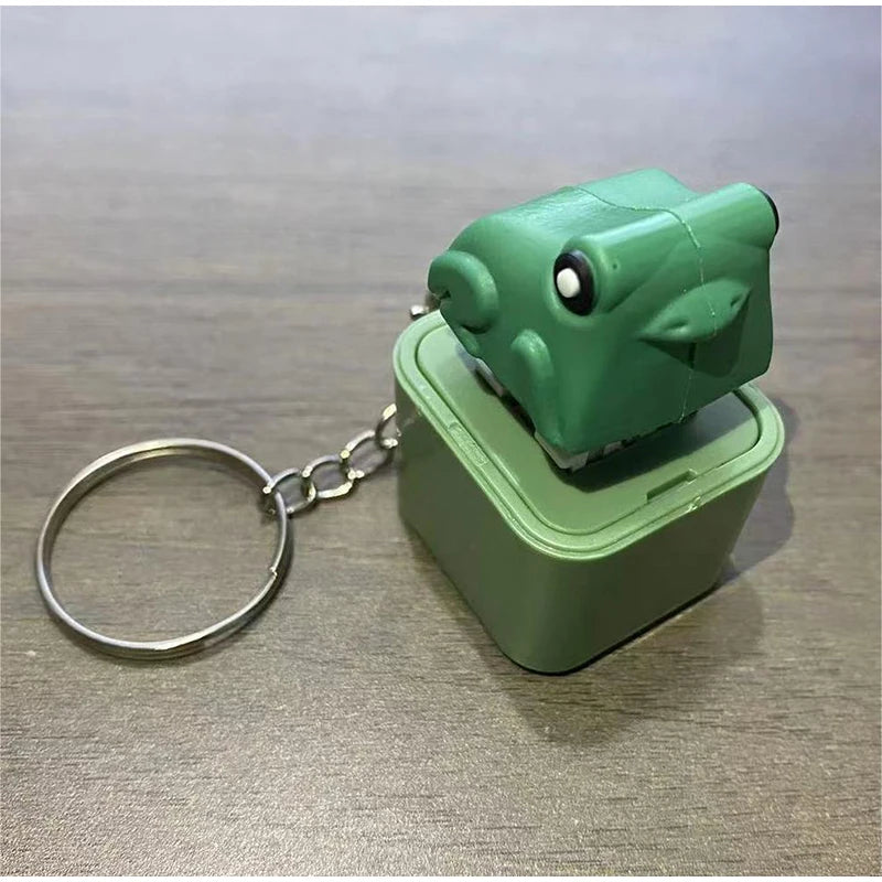 A green frog-shaped fidget keychain with a silver split ring attached.