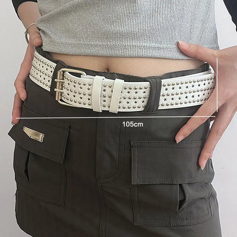 A close-up of a dark gray leather belt with silver bullet studs worn around the waist of a person wearing dark pants.