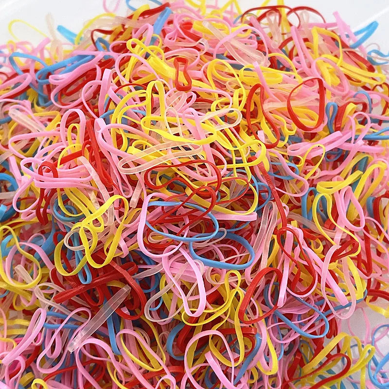 A pile of colorful disposable hair scrunchies in various shades of pink, yellow, and blue.