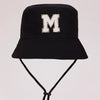 Black sun hat with a gold letter M print and an adjustable cord