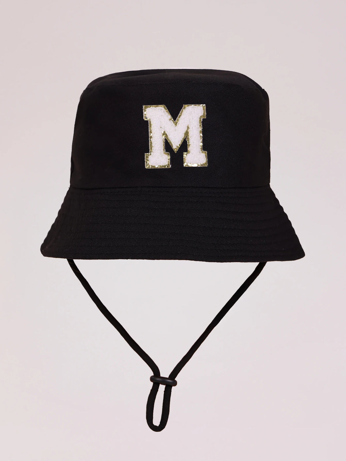 Black sun hat with a gold letter M print and an adjustable cord