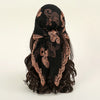 A black floral embroidered lace bandana headscarf tied in a voluminous knot.