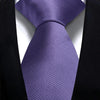 Lila gestreifter Krawattenknoten unter einem schwarzen Sakkojacke.