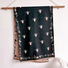 A dark green pashmina shawl with a floral print featuring small pink and white bees.