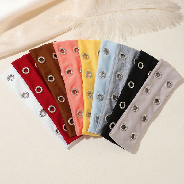 A collection of colorful punk style metal hollow headbands laid out on a light surface.