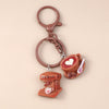 A brown leather coffee cup keychain featuring a small pink heart design.