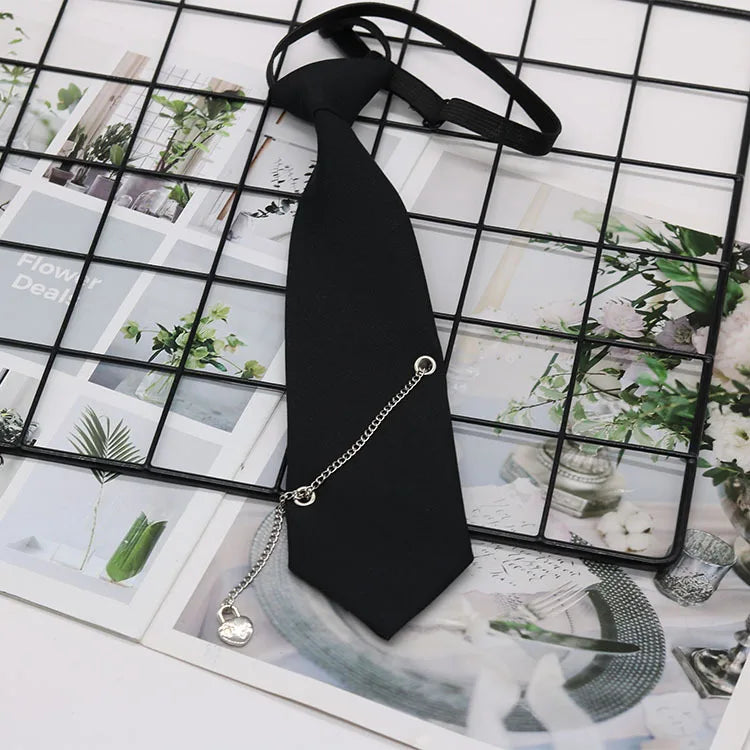 A black necktie with a silver chain attached, displayed on a grid background of floral and natural imagery.