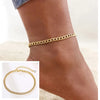 Gold stainless steel snake chain anklet worn on a woman's ankle.