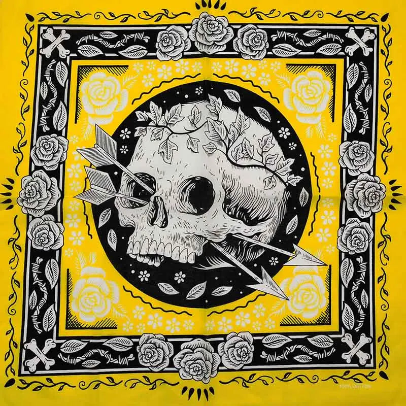 Diseño de calavera en blanco y negro enmarcado por rosas sobre una tela amarilla cuadrada.