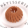 A close-up of elegant brown horsetail hair clips arranged in a circular pattern on a white plate.