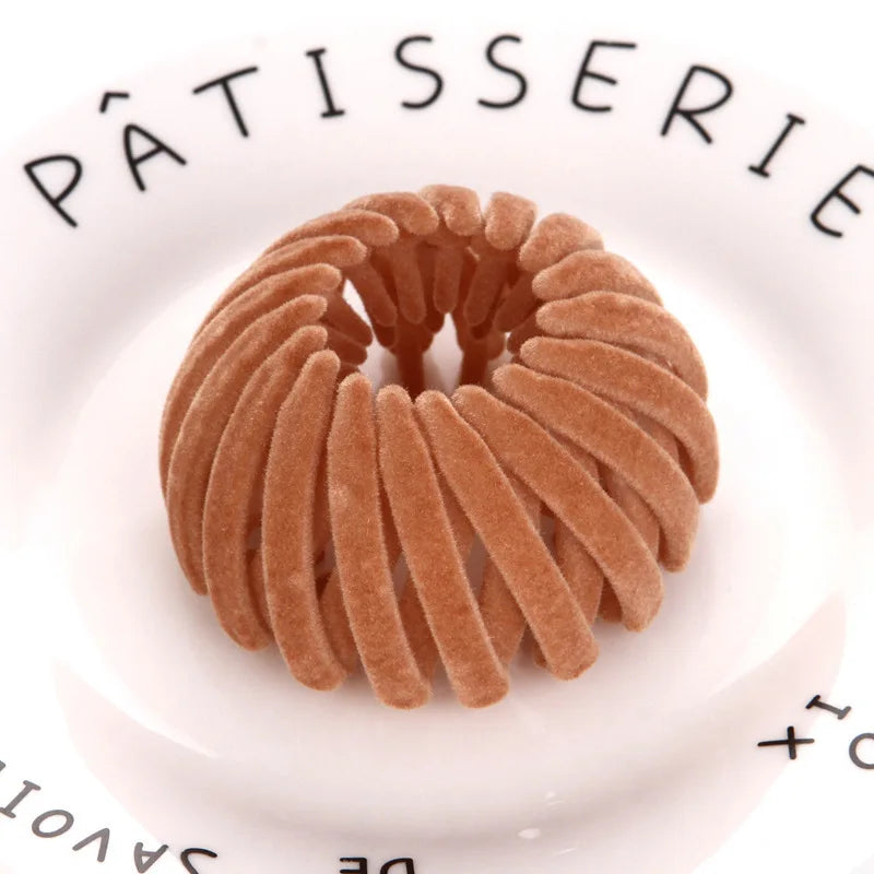 A close-up of elegant brown horsetail hair clips arranged in a circular pattern on a white plate.