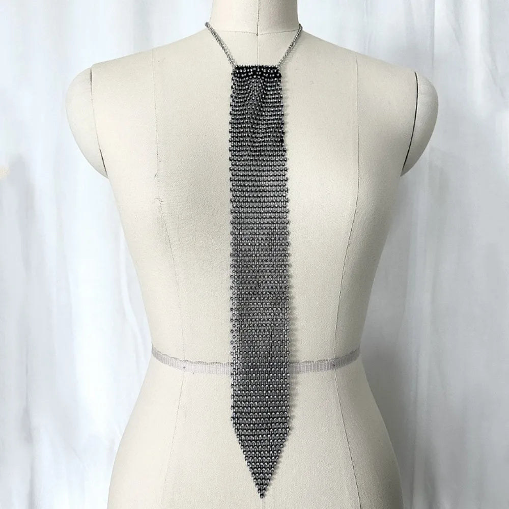 A long, silver crystal rhinestone sequin necklace displayed on a mannequin's neck.