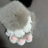 A pair of white and gray faux furry gloves with pink accents, resembling cartoon paws.