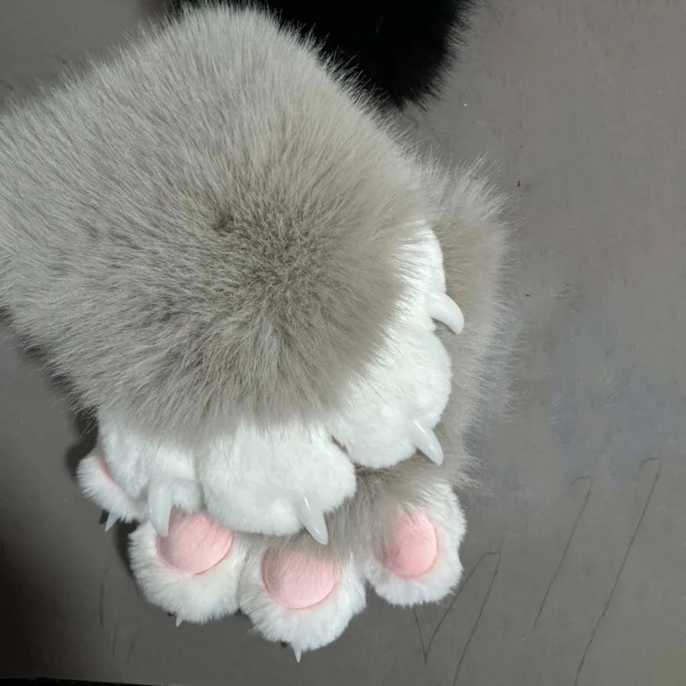 A pair of white and gray faux furry gloves with pink accents, resembling cartoon paws.