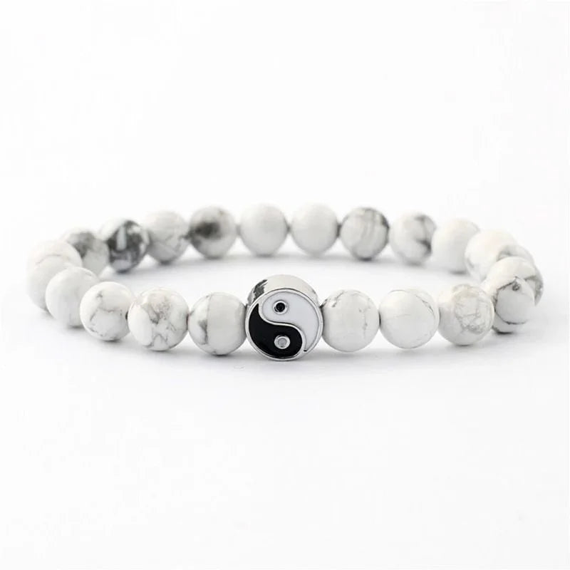 A silver and white marble Yin Yang hand string bracelet with round beads.