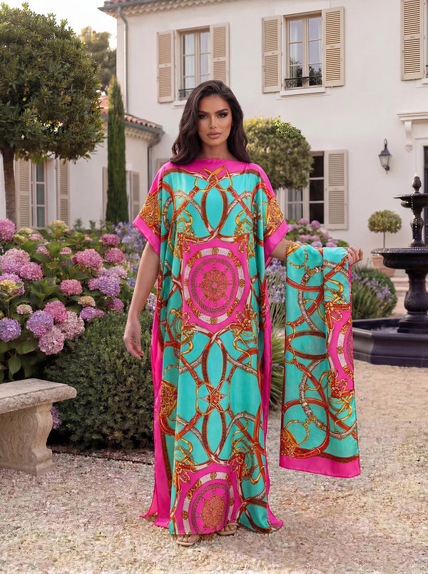 A woman wearing a flowing pink and teal geometric satin abaya scarf set outdoors near a classical building.