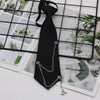 A black classic chain necktie is displayed against a grid background of photographic prints.