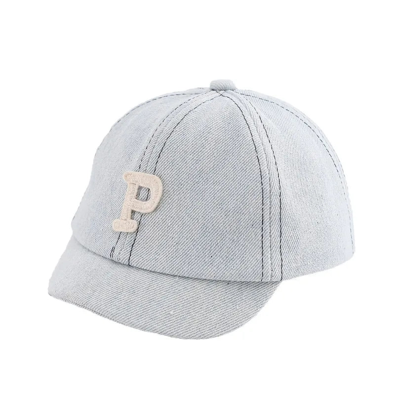 A light gray denim baseball cap with a tan embroidered letter P