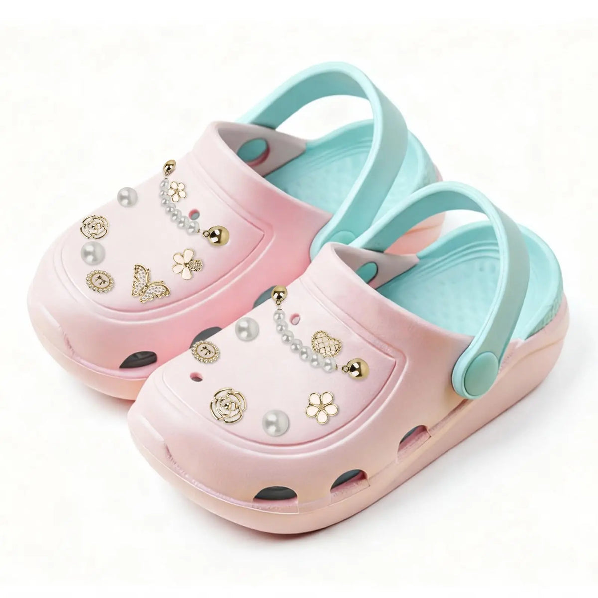Un par de zapatos infantiles rosa y azul claro decorados con charms de strass y purpurina.