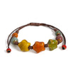A bracelet made of handmade glazed ceramic stars strung on a dark brown cord.