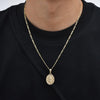 A gold chain necklace with a round pendant depicting the Virgin Mary prayer.