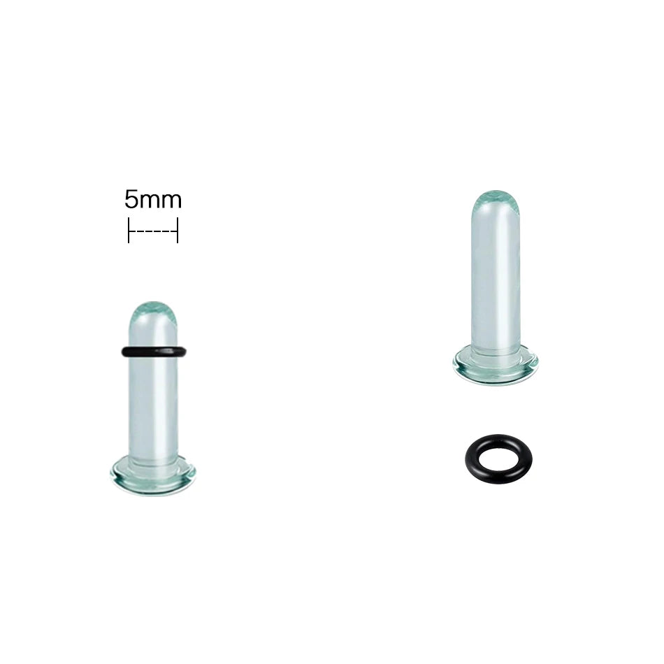 A glass ear stretching kit showing a cylindrical piece, a plug, and a black ring.