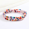 Una pulsera hecha de cuentas translúcidas y coloridas en tonos rosa, azul y rojo.