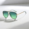 Retro large frame green fashion sunglasses with gold accents resting on a white surface.