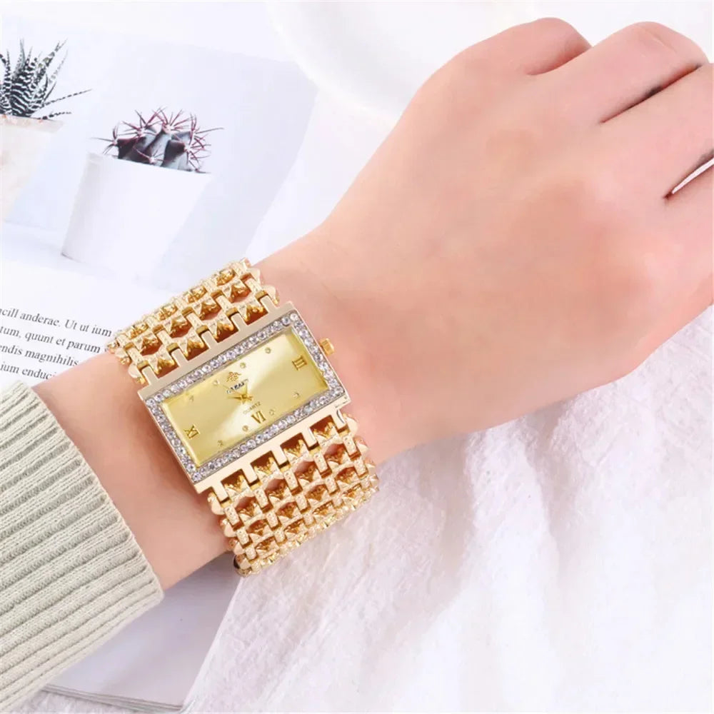 A close-up of a fashion quartz diamond watch with a gold stainless steel bracelet worn on a wrist.