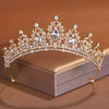 Diadema de cristal dorado brillante con intrincados diseños barrocos, mostrada en una caja.