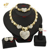 A gold heart crystal jewelry set featuring a necklace and earrings displayed on a black stand.