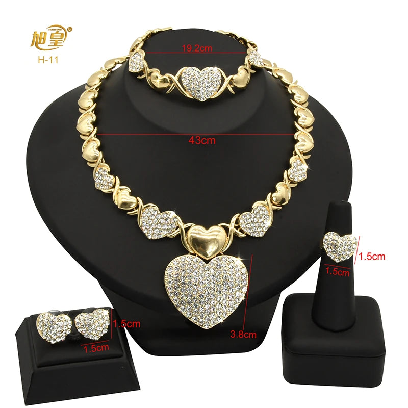 A gold heart crystal jewelry set featuring a necklace and earrings displayed on a black stand.