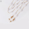 A delicate gold chain lanyard featuring small white pearls, displayed against a white background.